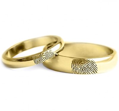 Обручальные кольца из желтого золота с отпечатками их владельцев