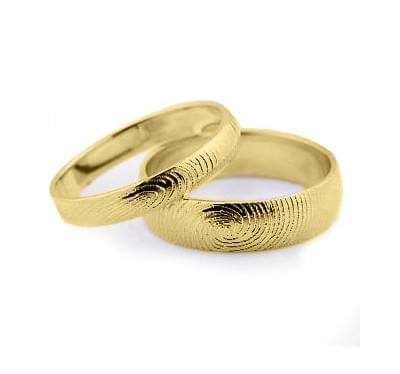 Обручальные кольца из желтого золота с отпечатками их владельцев